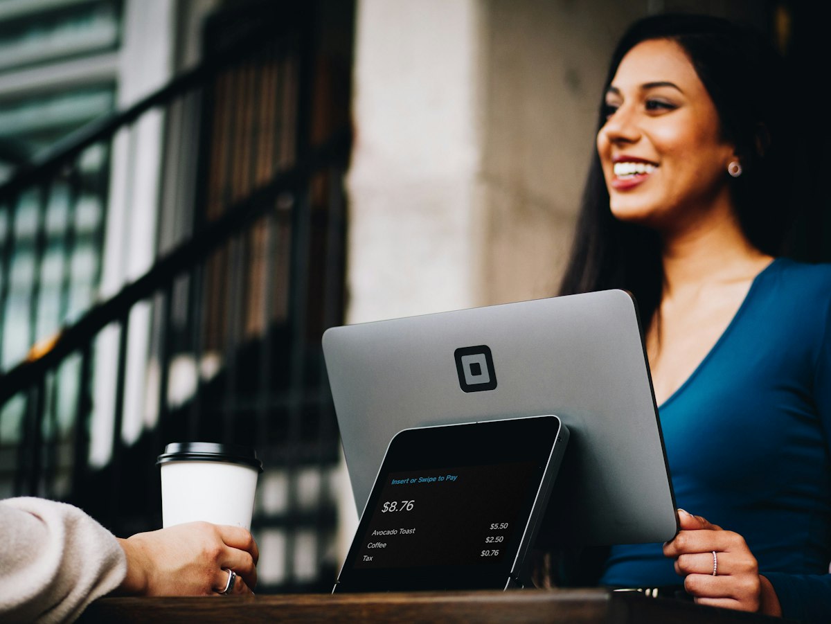A FlyJanuary.org travel consultant smiling while talking a client through January fare options across a laptop
