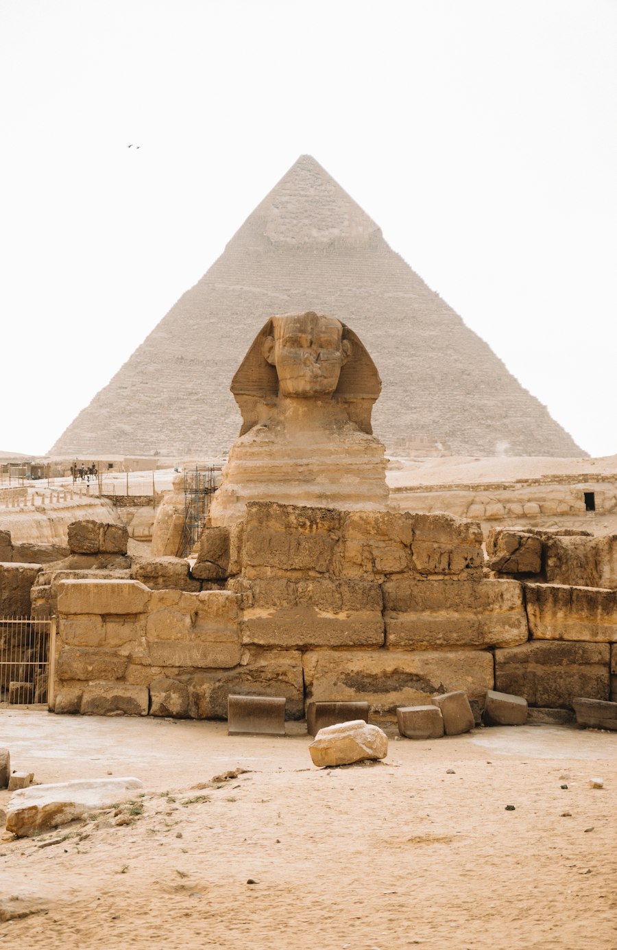The Great Sphinx of Giza with the Pyramid of Khafre behind it under a pale sky