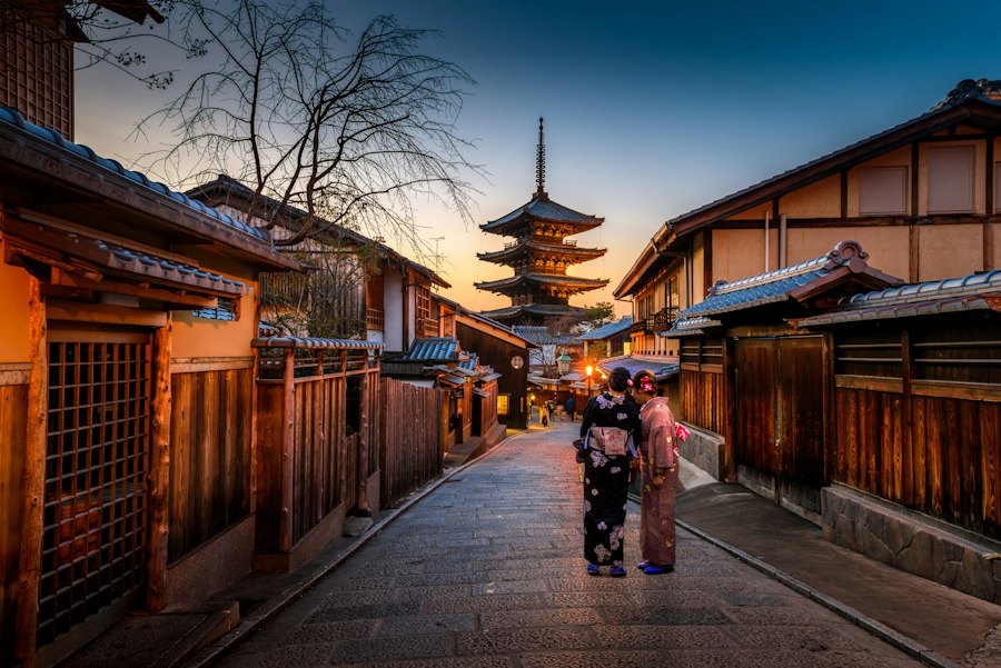 Lantern-lit lane in Kyoto leading towards the Yasaka Pagoda at dusk