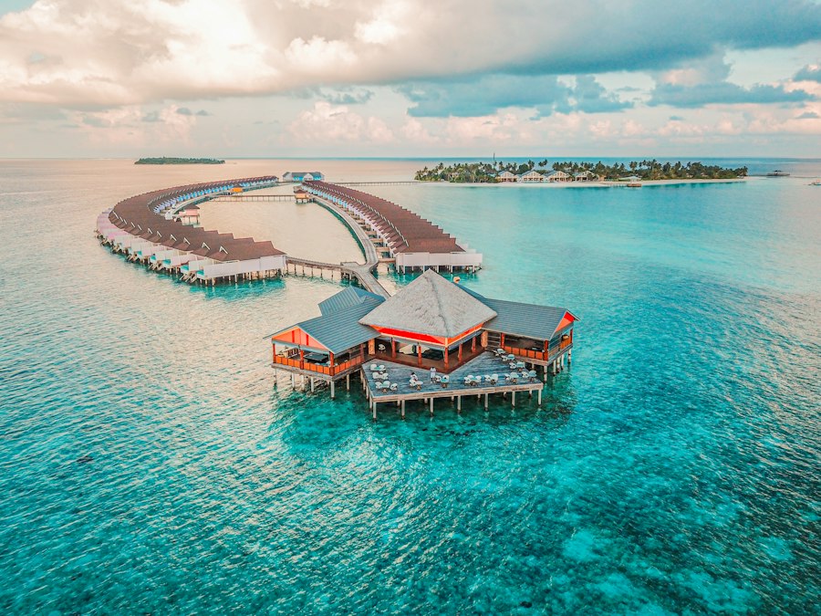 Aerial view of overwater villas above turquoise lagoon water in the Maldives