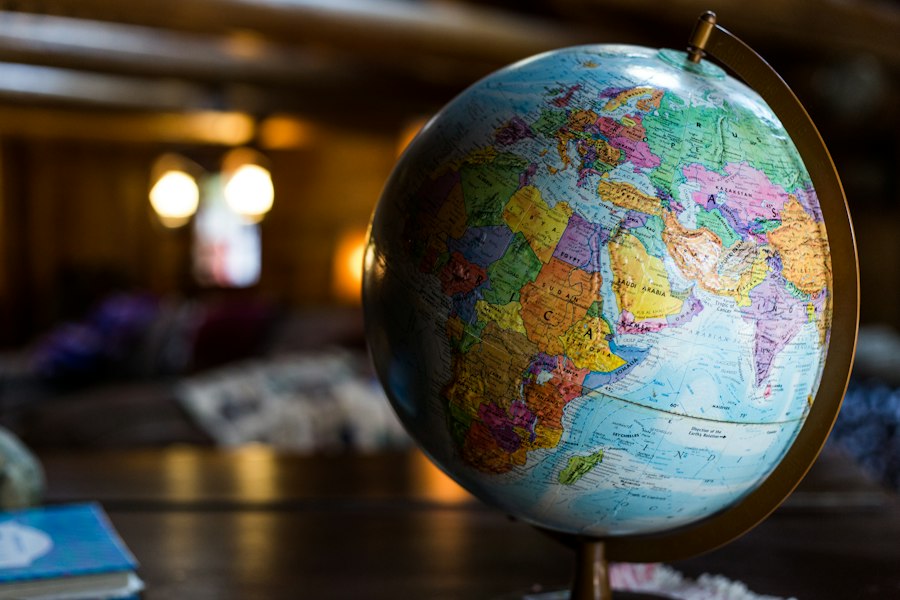 Desk globe lit by warm low light beside notes for a January departure plan
