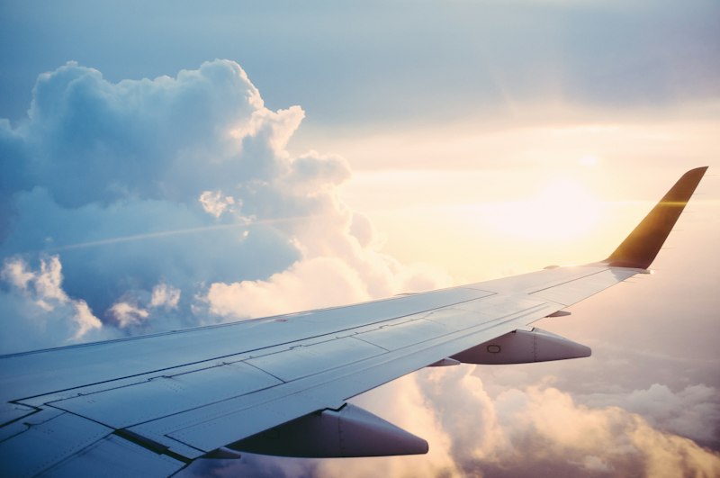 Aircraft wing above a sunlit cloud layer on a long-haul January flight